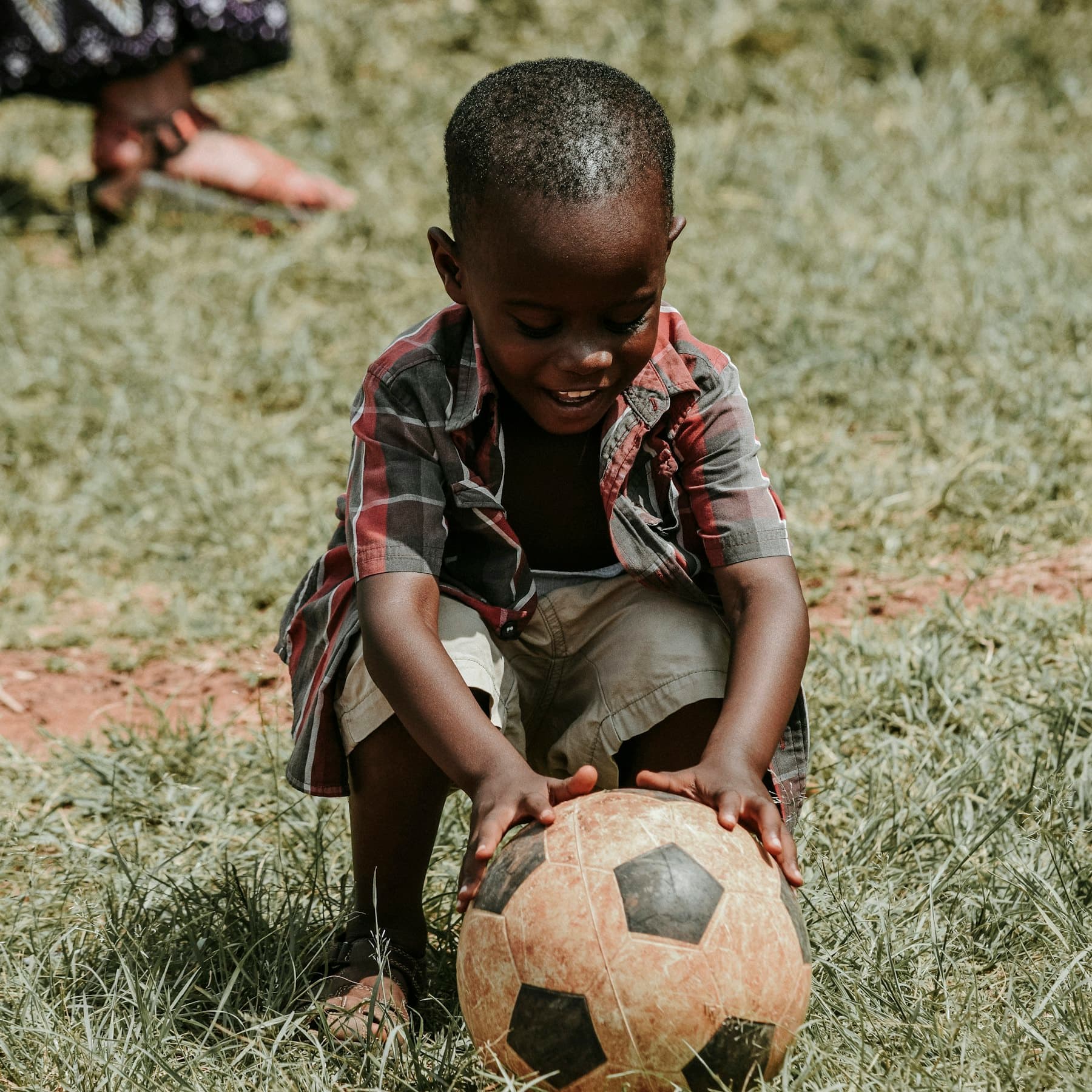 Un enfant souriant tenant un ballon de football